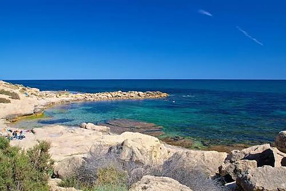 Una de las calas del Cabo de las Huertas, con la roca y el agua clara